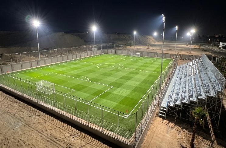 Floodlit full-size football pitch with artificial turf and spectator stands at Sharm Sports Club